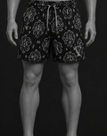 Mannequin wearing black patterned shorts on a black background